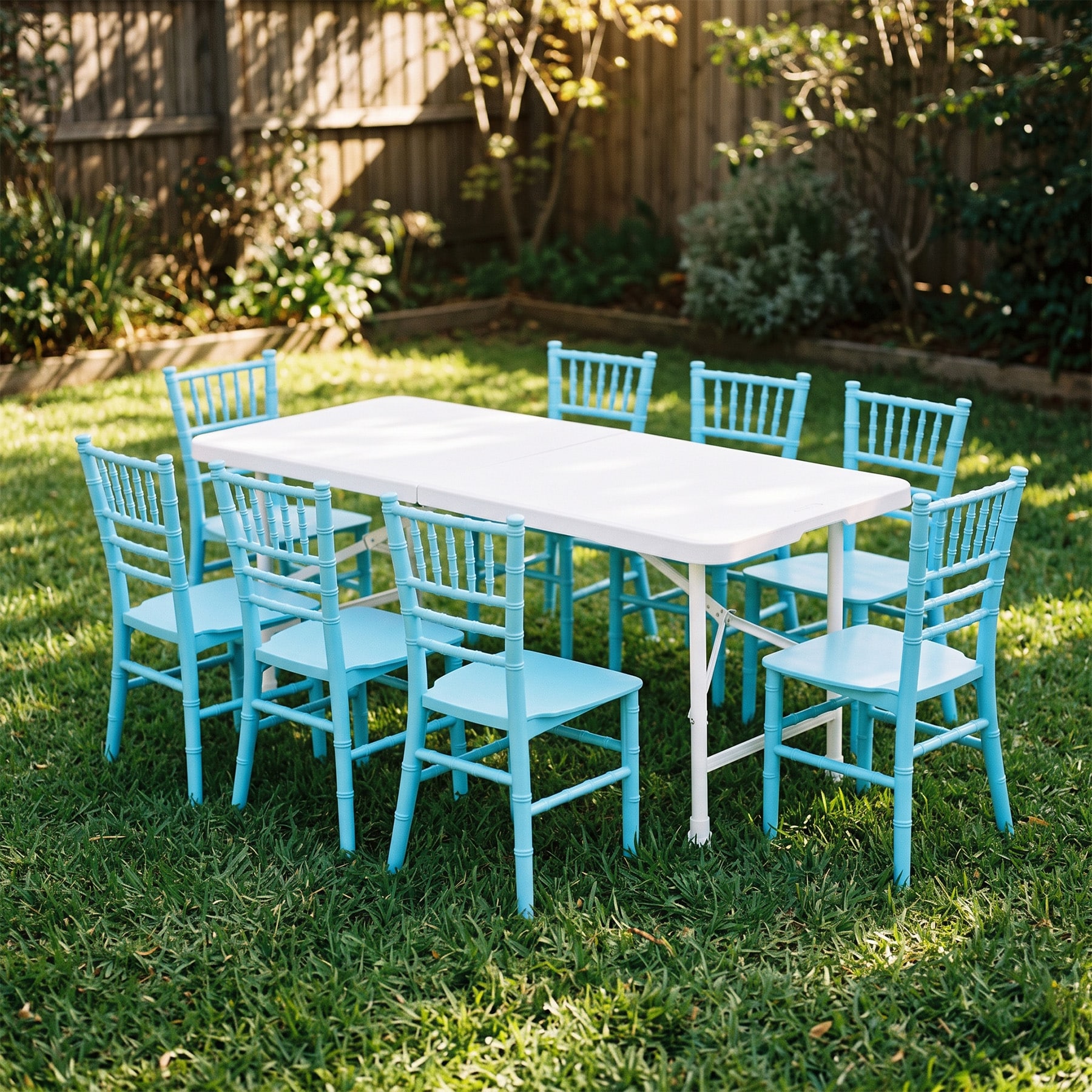 White kids folding table on a backyard lawn with eight light blue child size Tiffany chairs