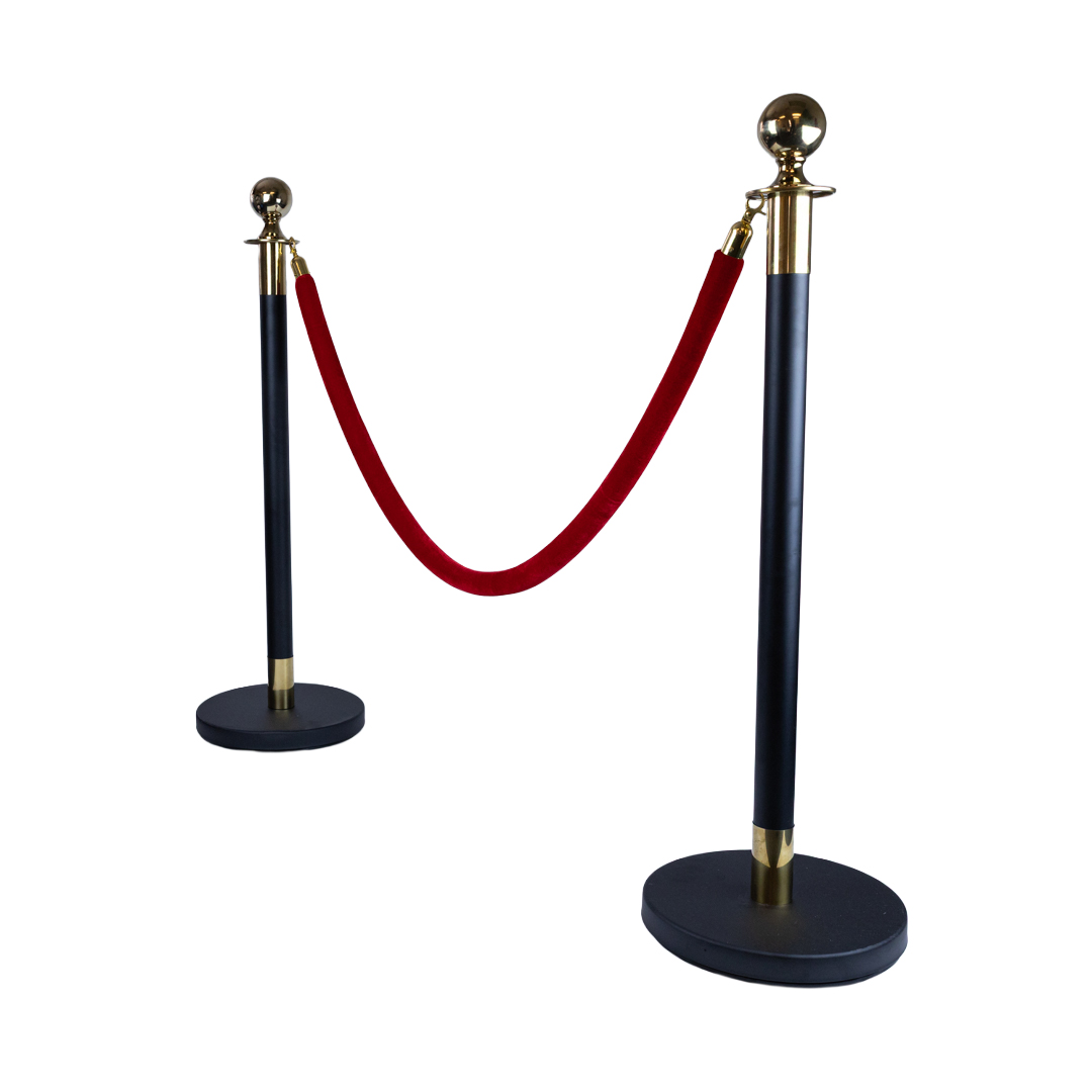 Black and gold VIP stanchion poles with red velvet barrier rope used for luxury crowd control at events and entry areas
