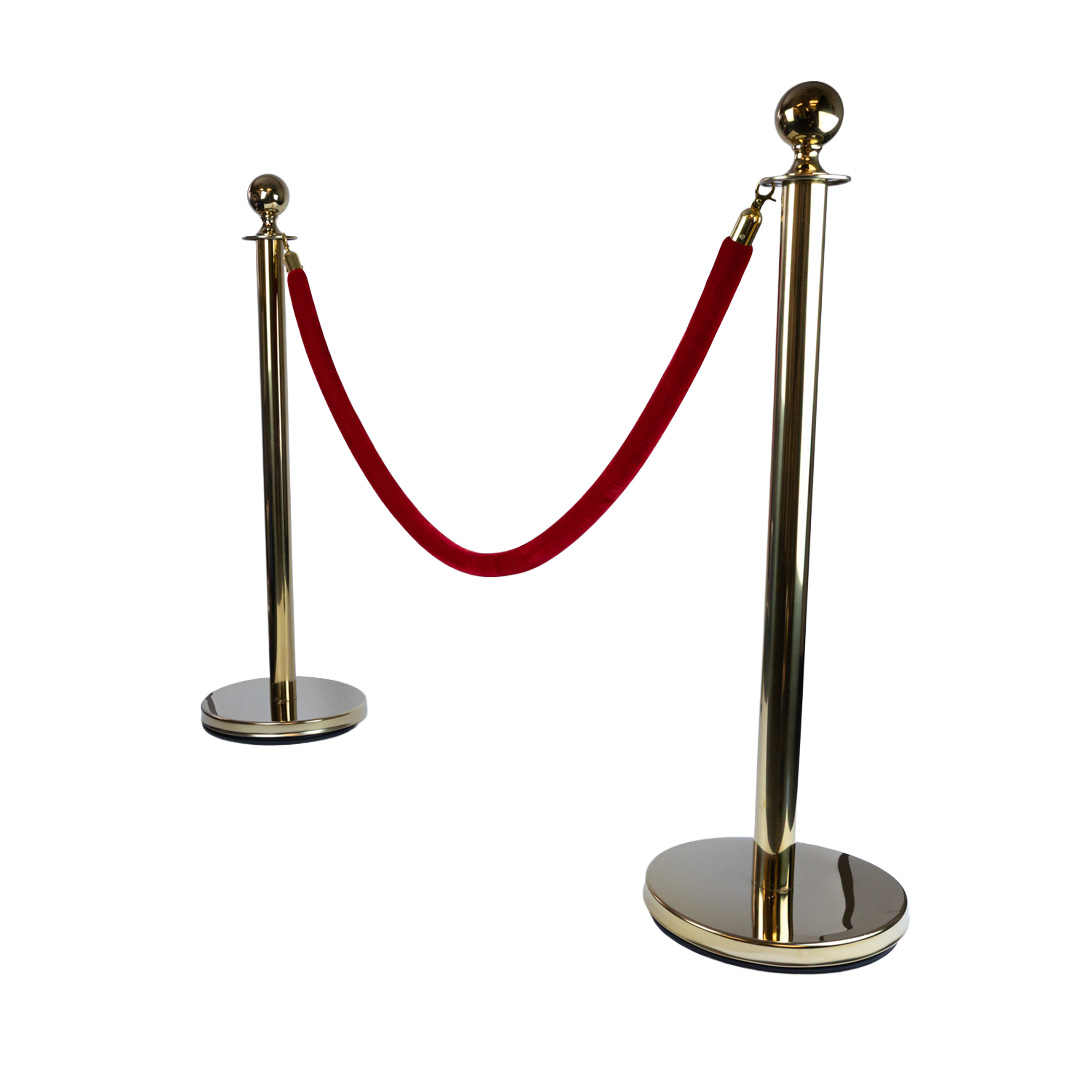 Gold stanchion poles with red velvet rope used as premium VIP barrier system for events and queue management