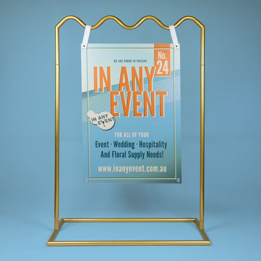 Gold Wave Signage Stand Displaying Event Sign on Blue Background - Ideal for Weddings & Corporate Events