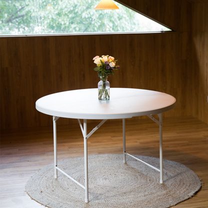 Round trestle table styled indoors with flowers, ideal for cafes, restaurants, or home entertaining