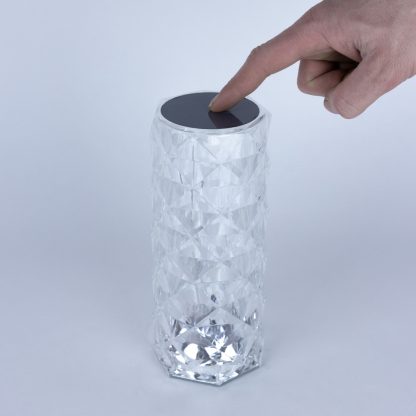 Hand touching the top of the crystal touch lamp to activate the LED touch control function with easy operation.