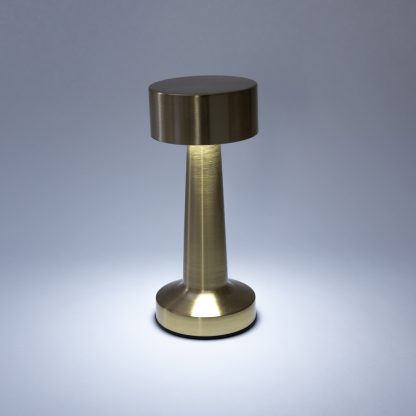 Gold metal LED mushroom lamp turned on in cool white light showing modern ambient lighting