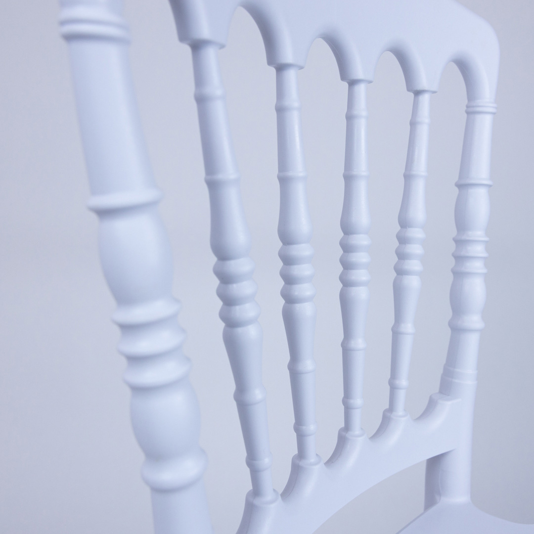 Close-up of elegant spindled backrest detailing on the white resin kids Napoleon chair – durable and stylish event furniture for children.