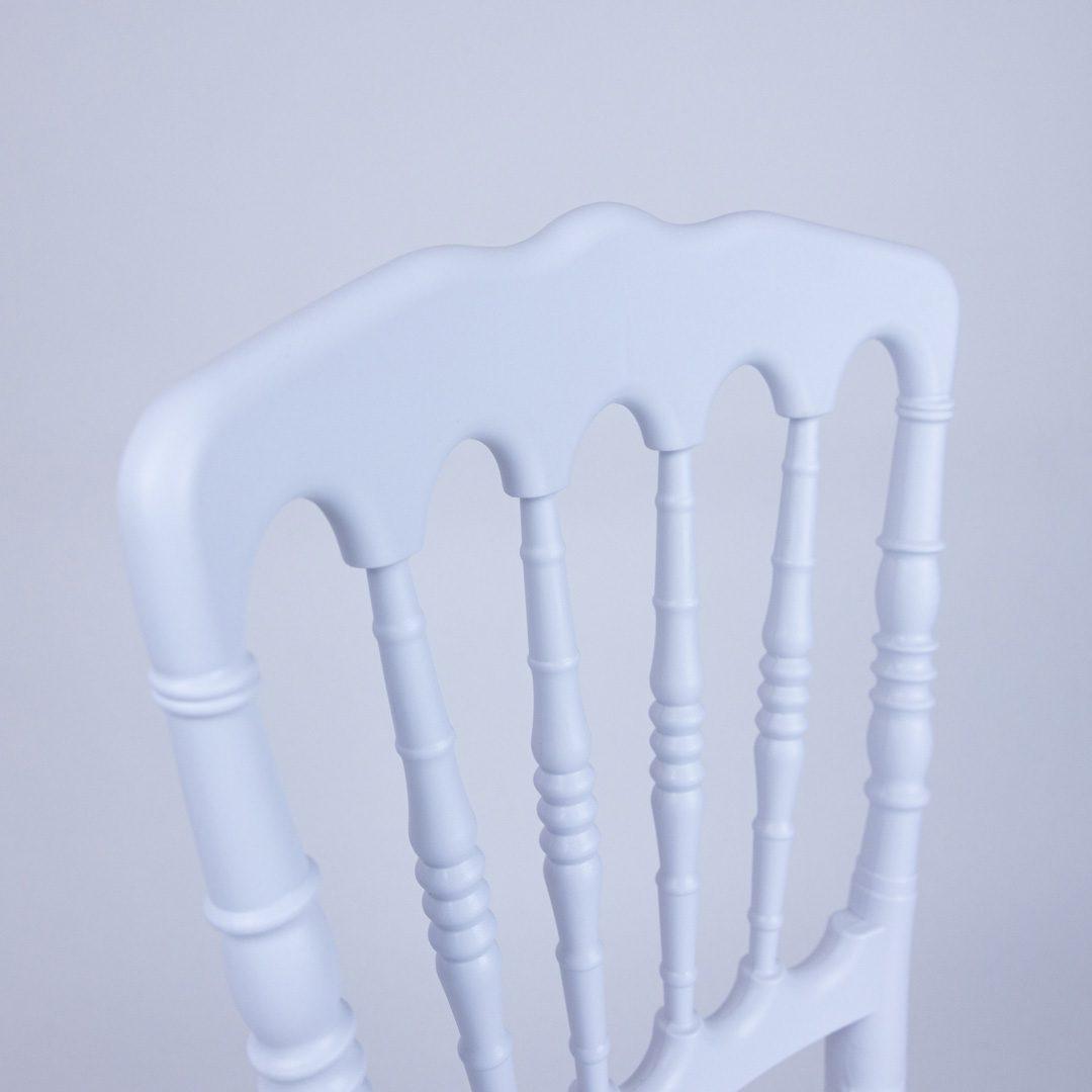 Detailed view of the curved top rail and decorative backrest of the white child size Napoleon chair, highlighting craftsmanship and resin finish.
