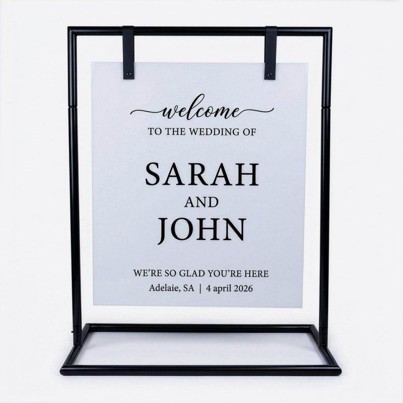 White acrylic wedding welcome sign displayed on black metal sign stand