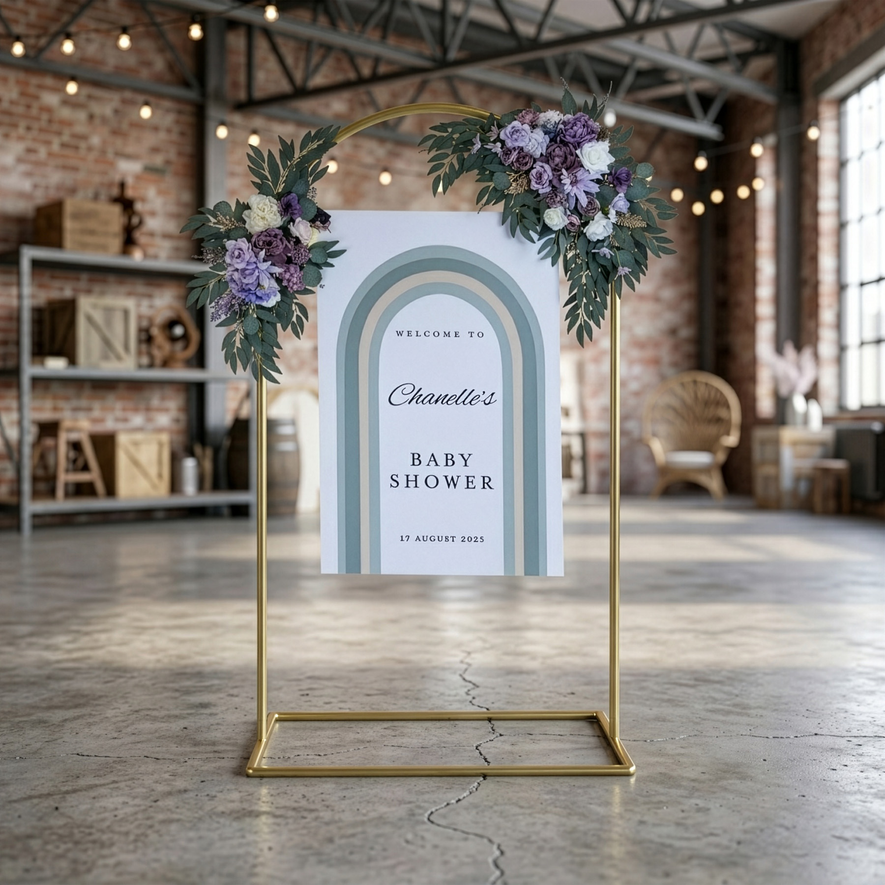 Gold arch signage stand styled with florals and hanging sign in event venue setting