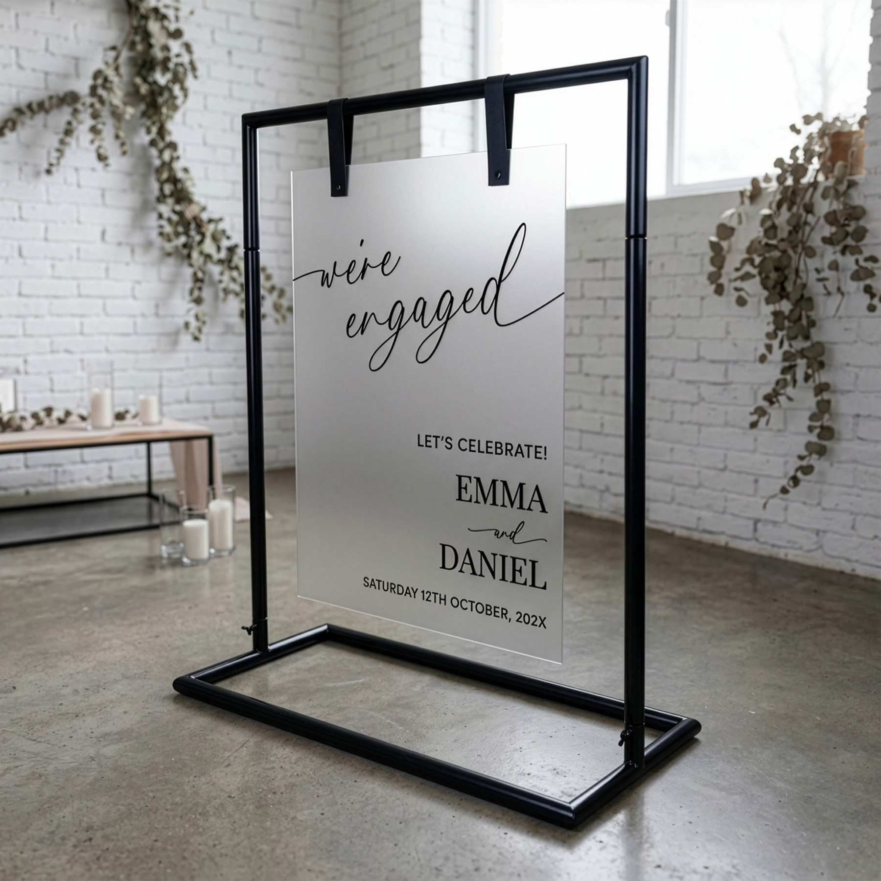 Frosted acrylic sign board displayed on black signage stand as engagement event sign