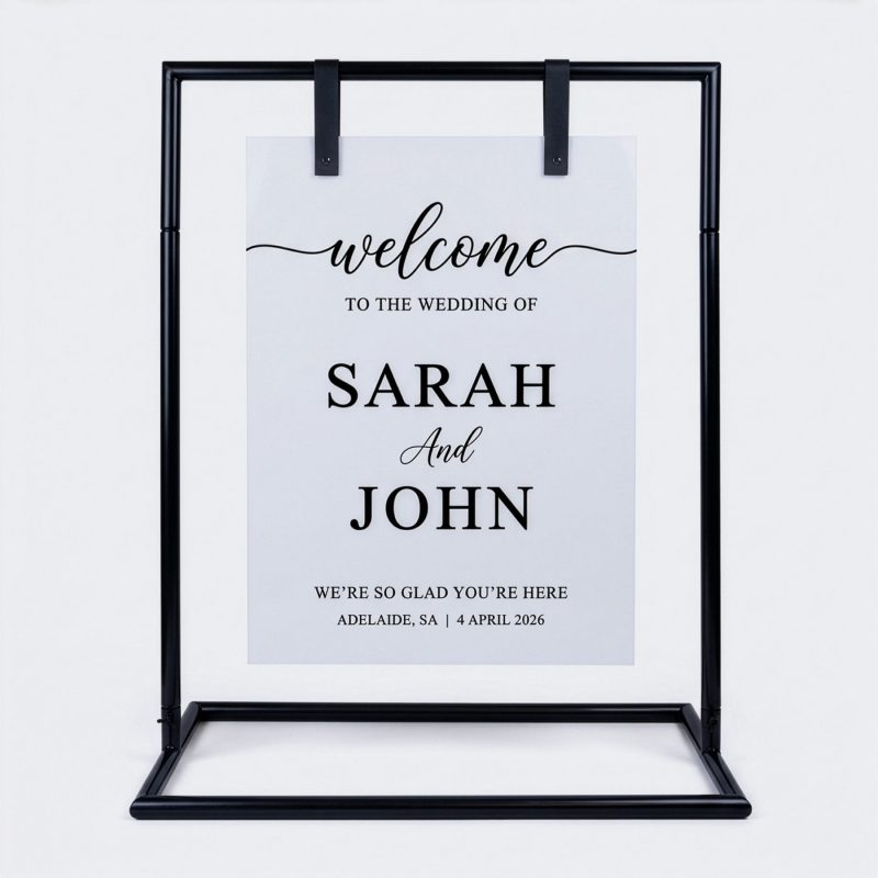 White acrylic sign board displayed on black signage stand as wedding welcome sign