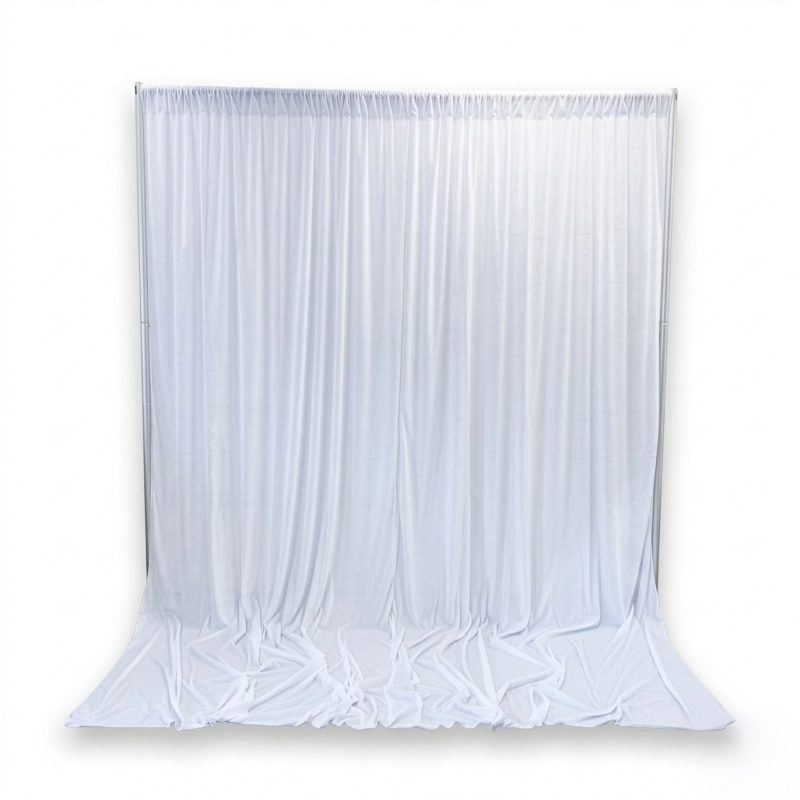 Full view of white velvet backdrop curtain styled on a backdrop stand with pooled fabric